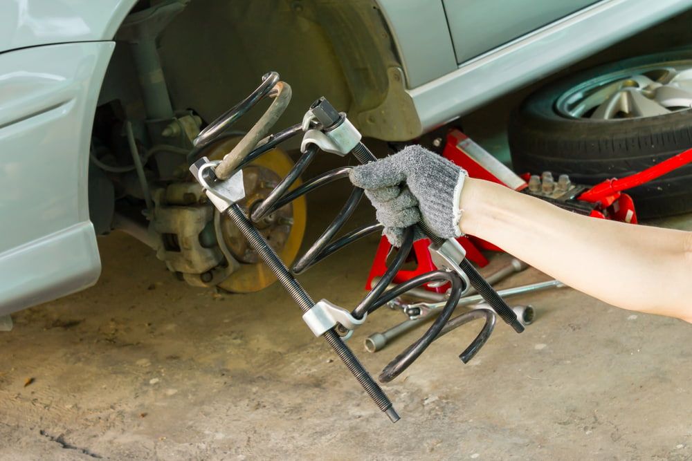 A Person is Holding a Tool in Front of a Car — Express Auto Repairs in Ainslie, ACT
