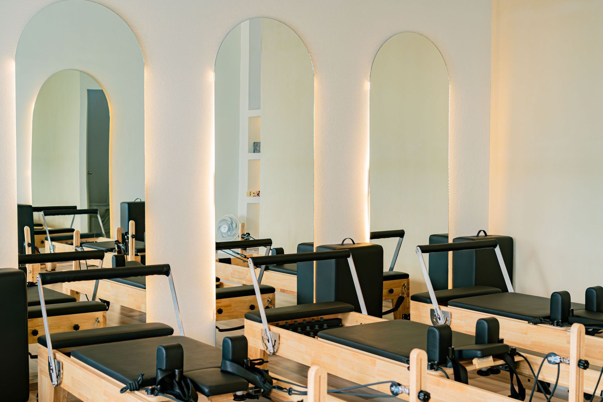 Instructor guiding a student on a Pilates reformer