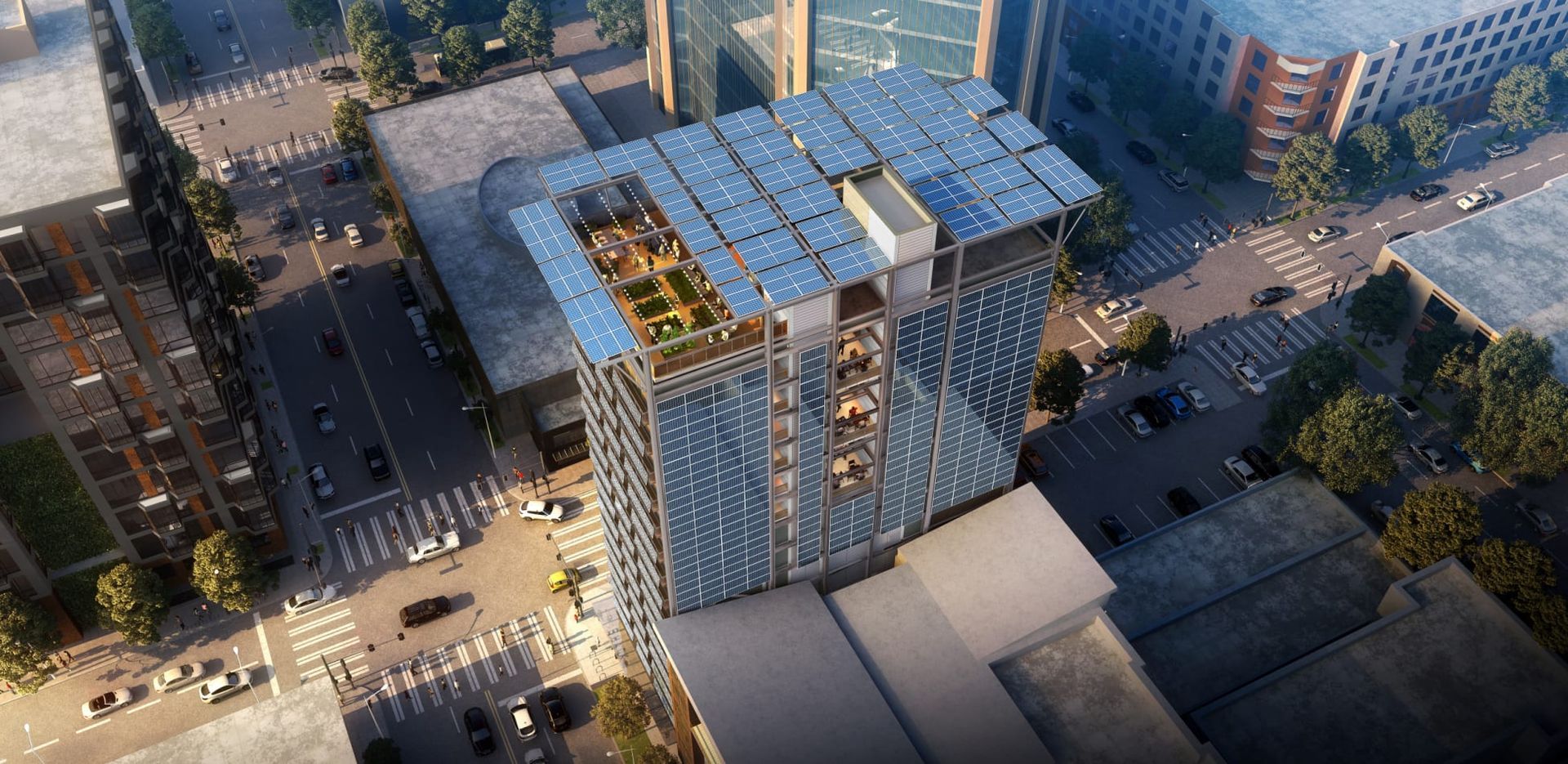 An aerial view of a building with solar panels on the roof in a city.