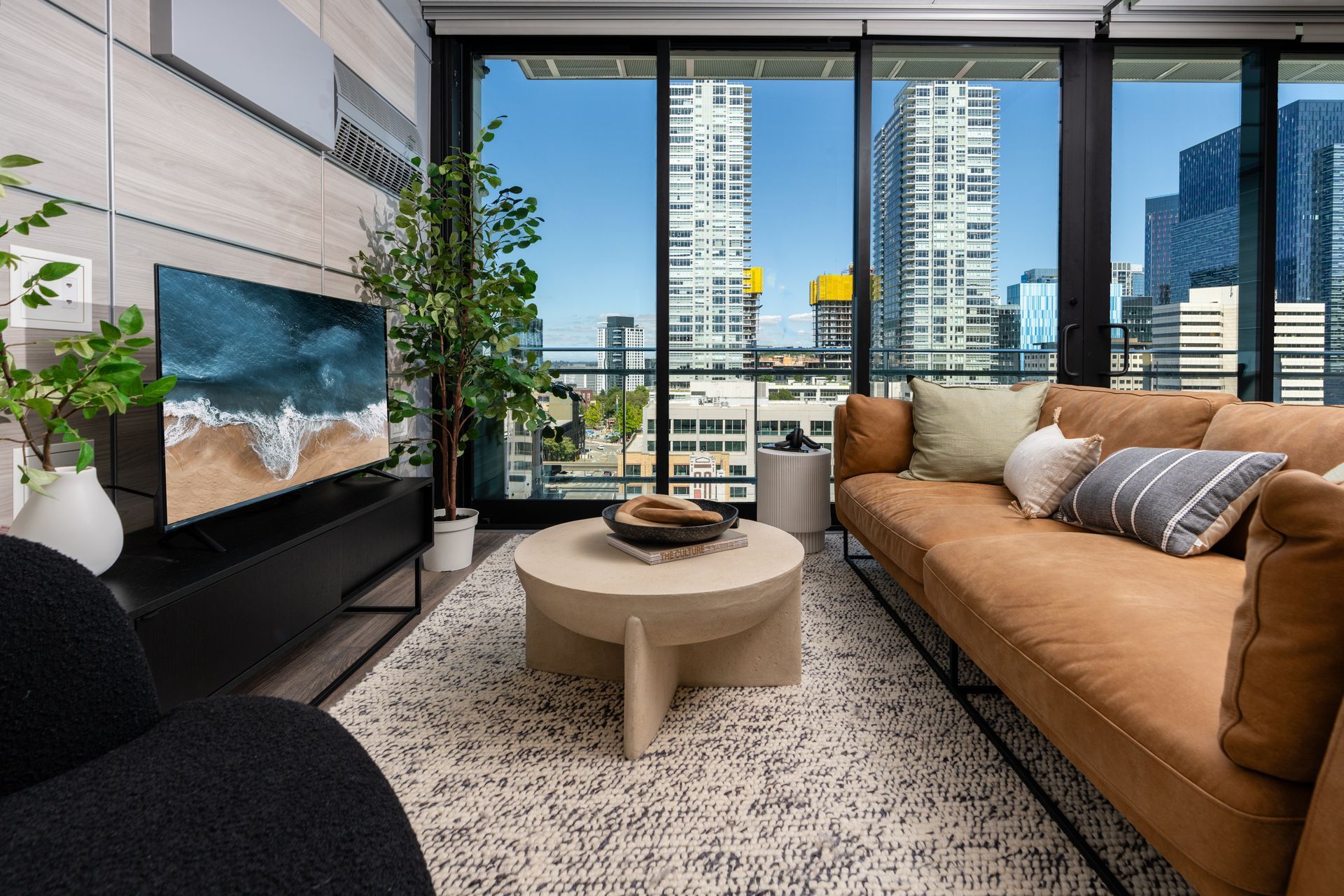 A living room with a couch, coffee table, and television.