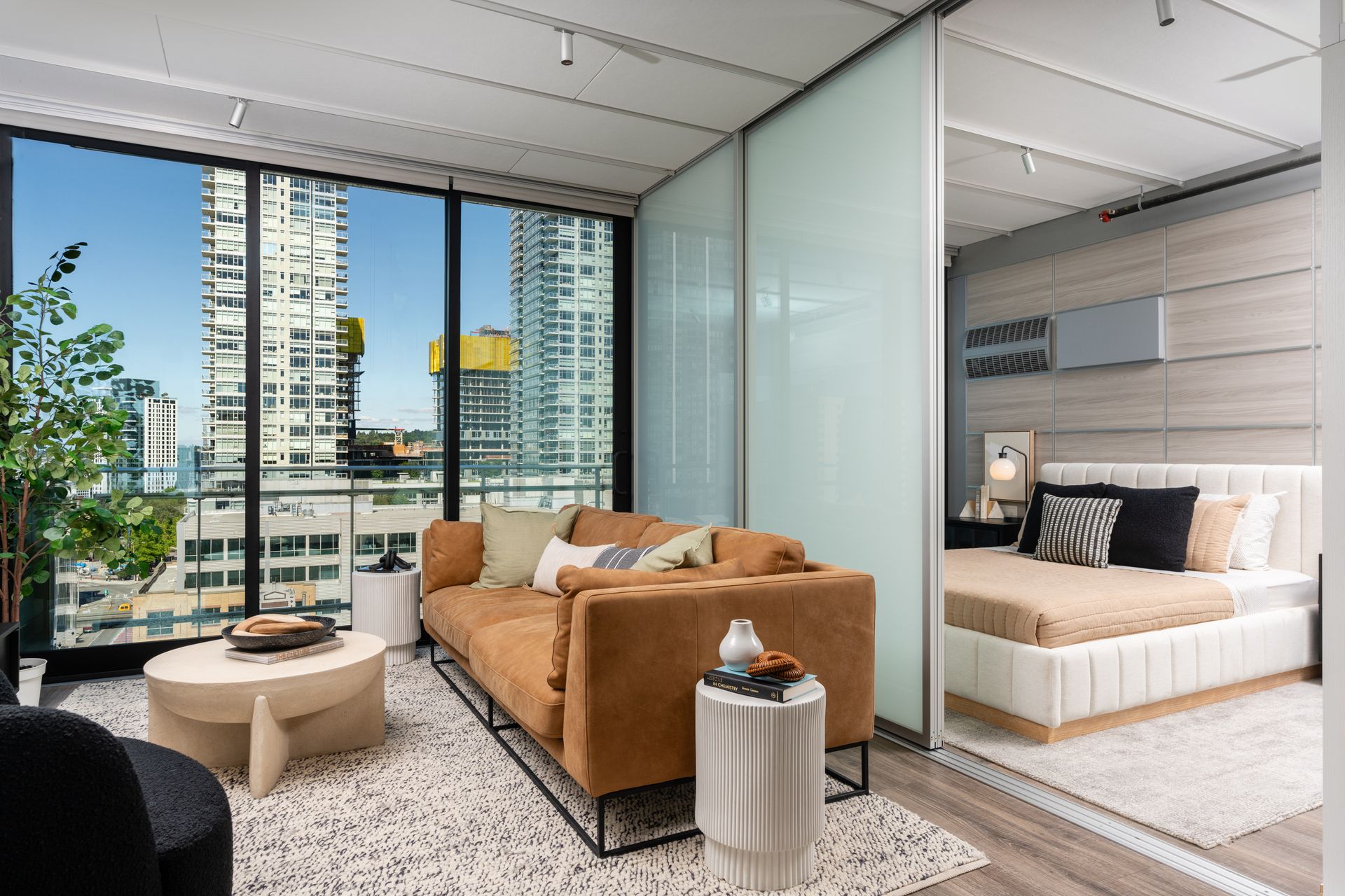 A living room with a couch, coffee table, and bed.