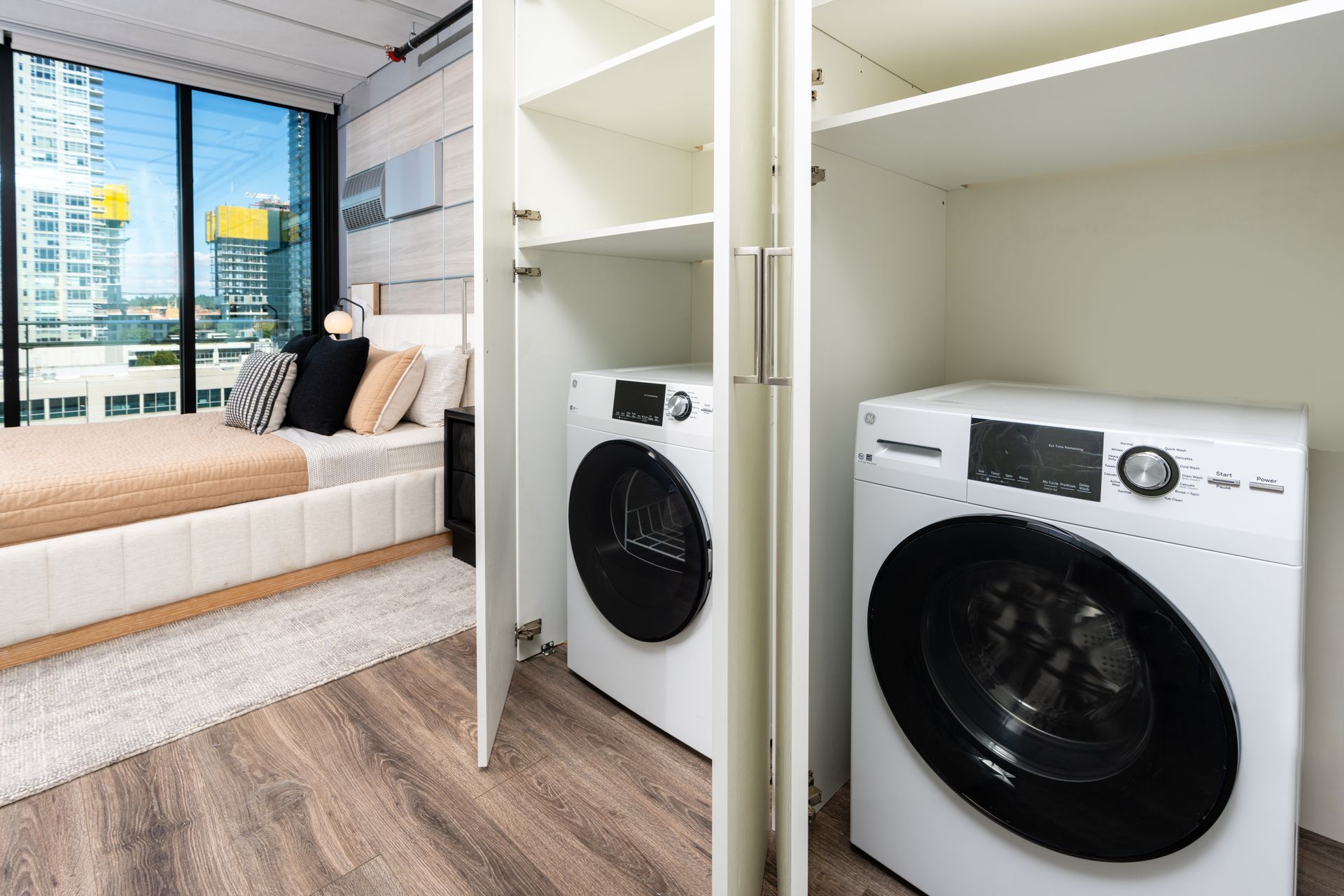A bedroom with a bed and a washer and dryer in a closet.