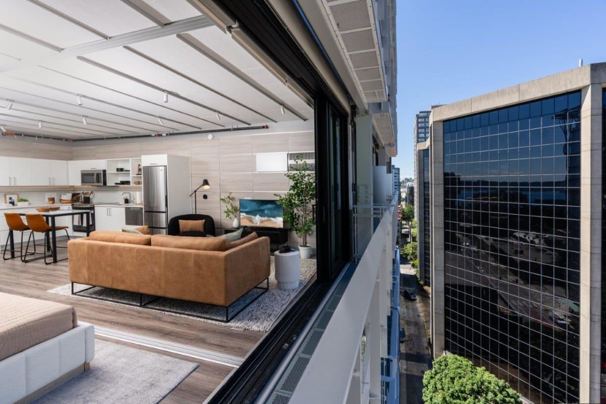 A view of a living room and a kitchen from a balcony.