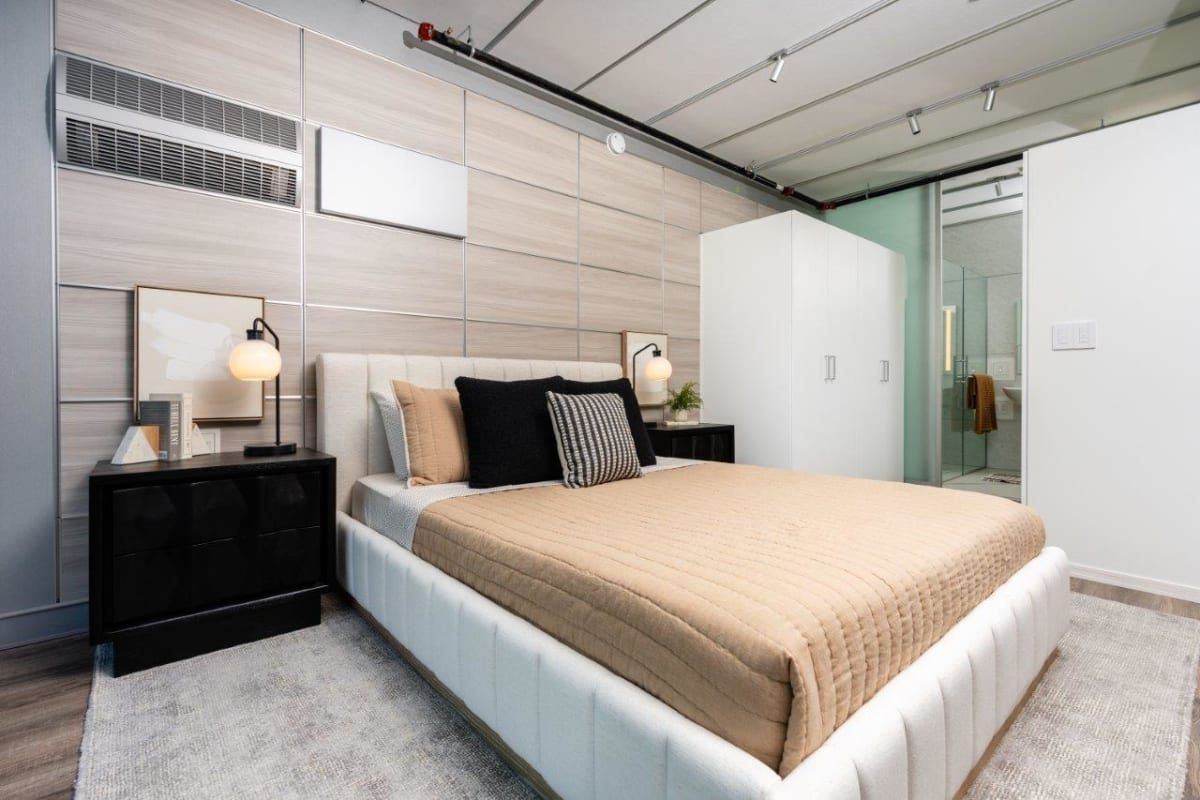 A bedroom with a bed, nightstands, and a bathroom.