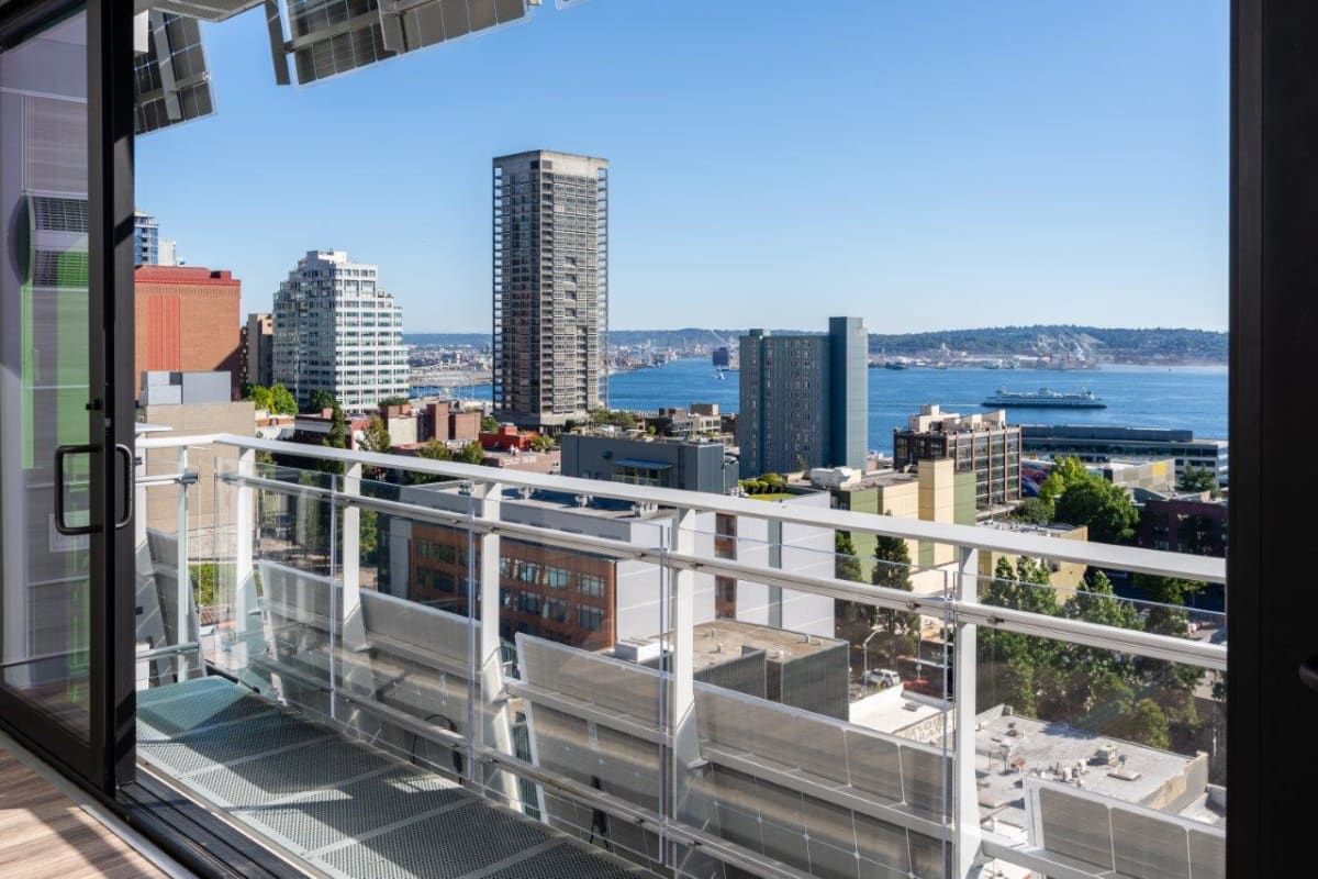 A balcony with a view of a city and a body of water.