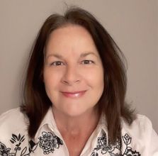 A woman wearing a white shirt with black flowers on it