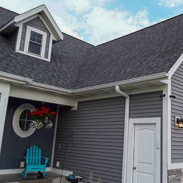 There is a blue chair on the porch of a house.