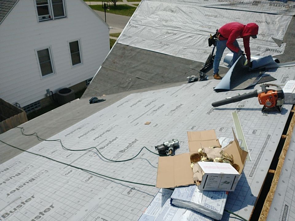 A man in a red hoodie is working on a roof