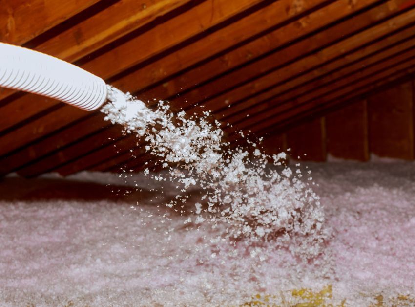 A white hose is spraying water into a room