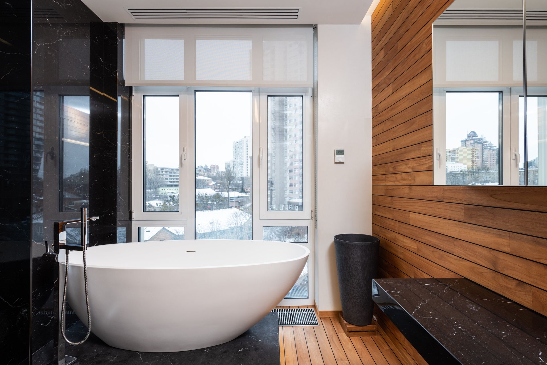 A bathroom with a large tub and a large window.