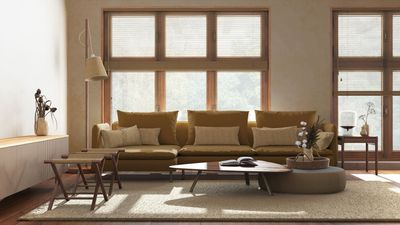 A living room with a couch , coffee table , chairs and lots of windows.