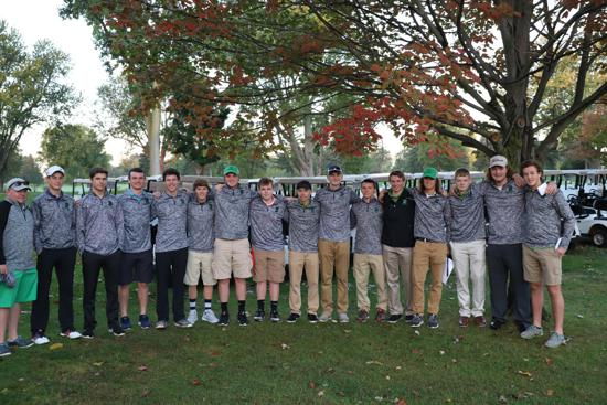 Group of people standing outdoors in matching gray jackets under trees, posing for a team photo.