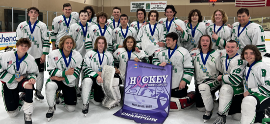 Ice hockey team posing in white and green uniforms with an H. Key banner at center.