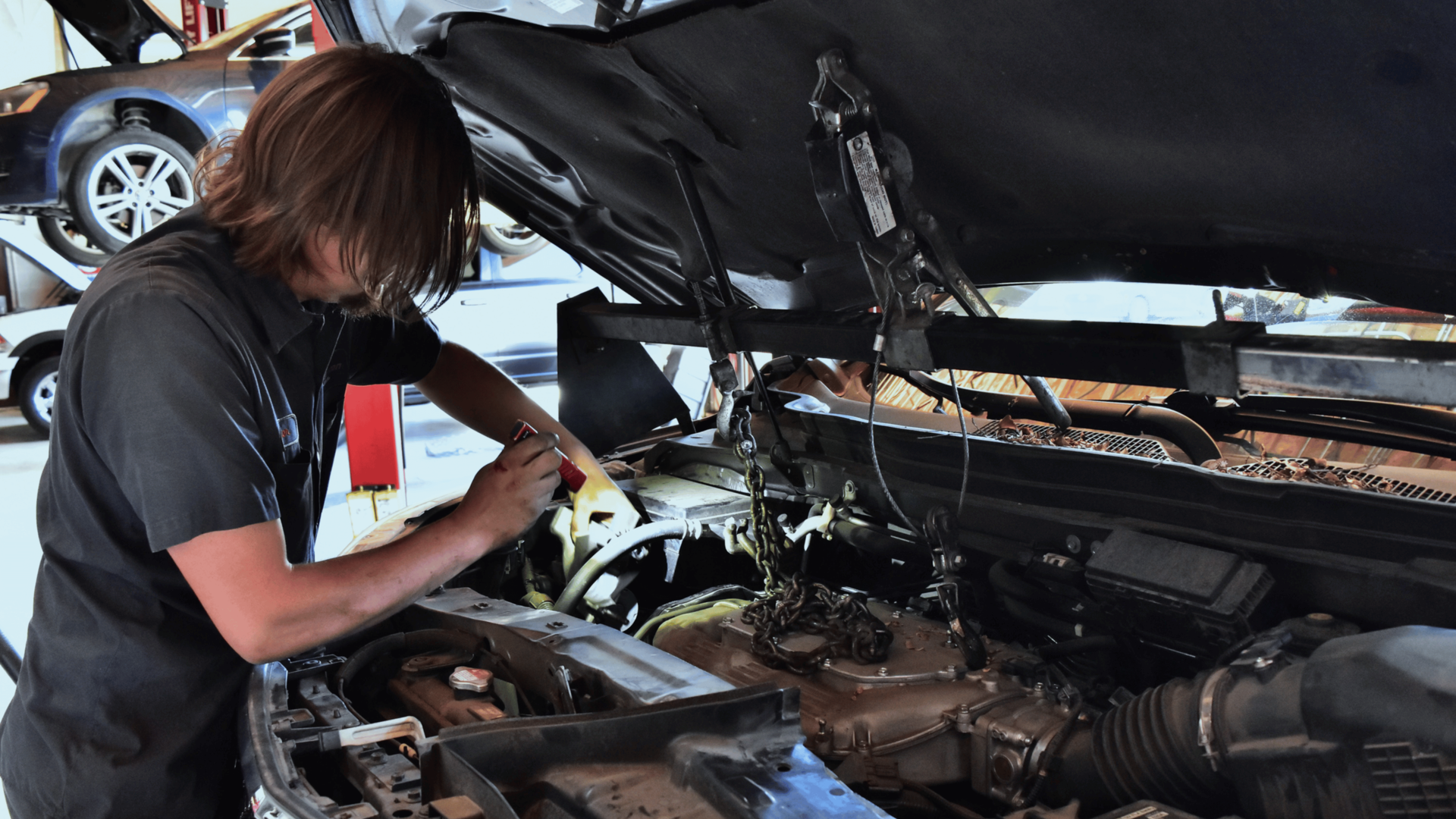 Tech replacing a timing belt and water pump during engine maintenance and cooling system service