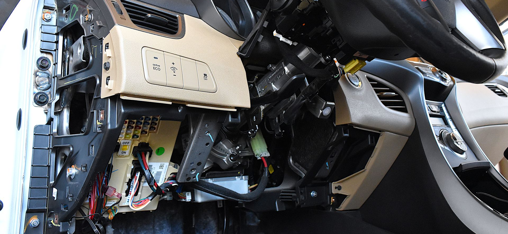Vehicle interior showing exposed steering column and components during diagnostic service.