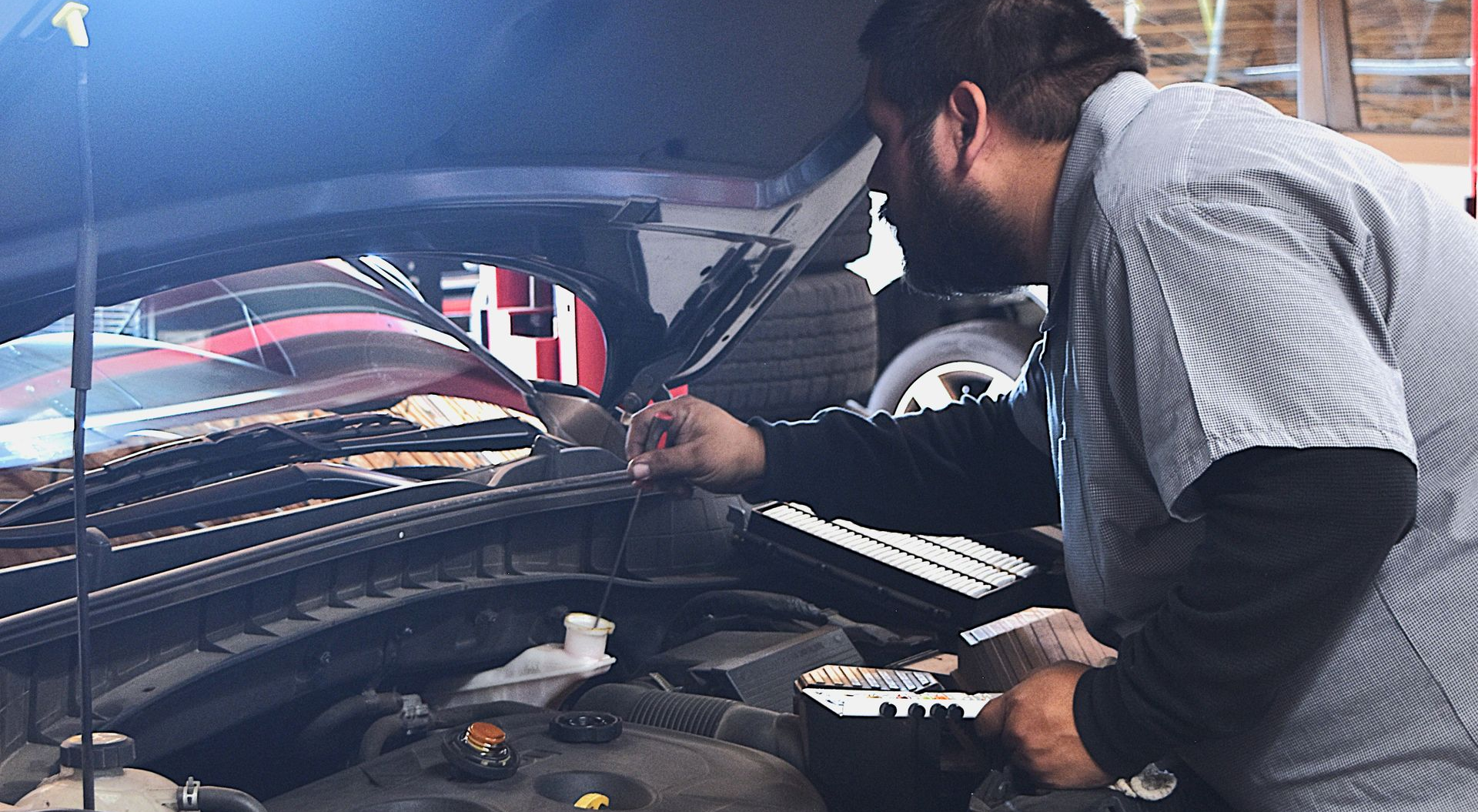 Precision Tire and Auto Center technician inspecting engine components during a tune-up in Phoenix