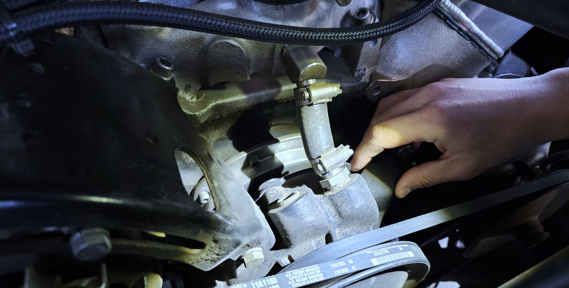 Auto repair technician assessing a vehicle water pump and cooling system components