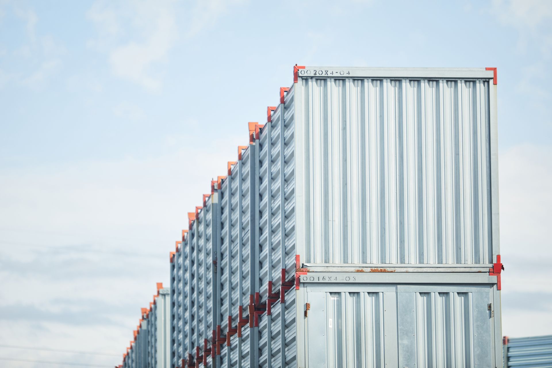 Multiple steel storage containers stacked at commercial facility