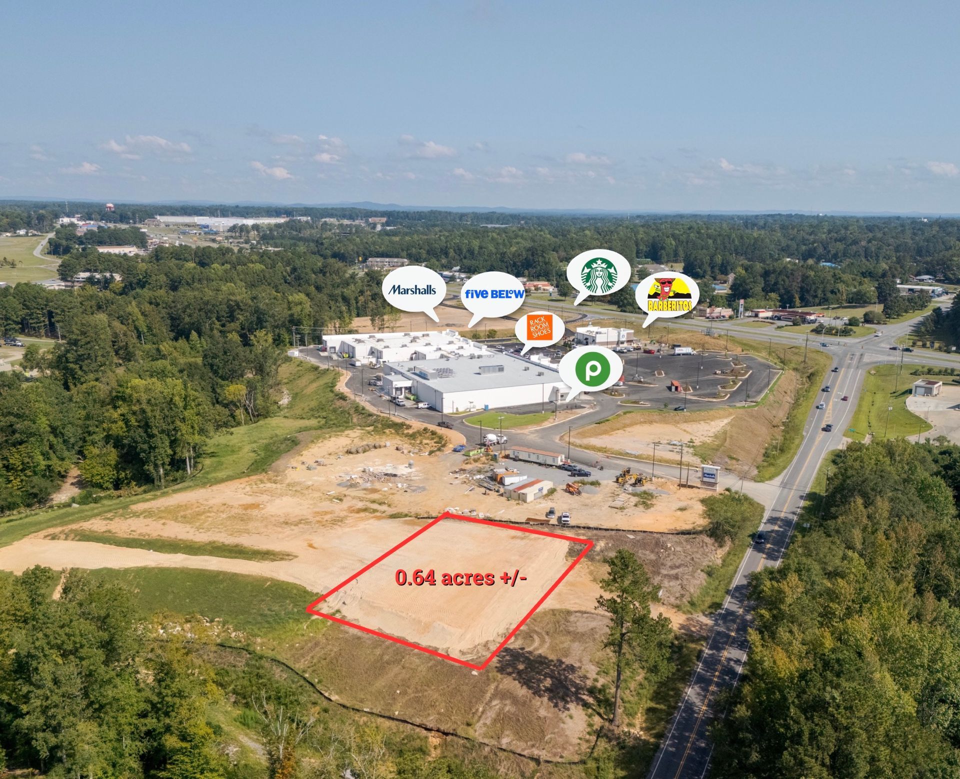 An aerial view of a development site with a 1.61-acre plot outlined in red, near a shopping center with retail logos.