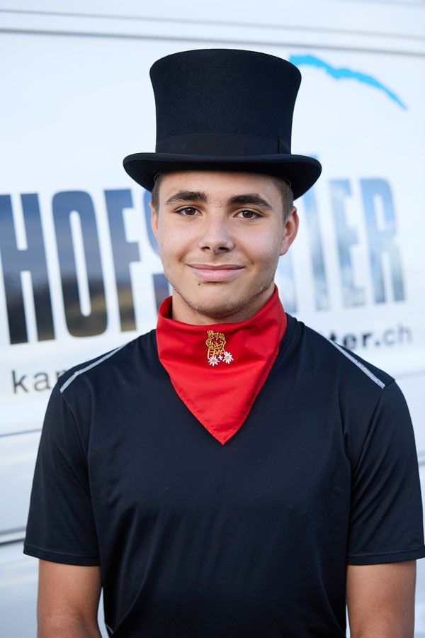Matia Hofstetter in einem weissen Hemd und Hut steht vor einem weissen Lieferwagen