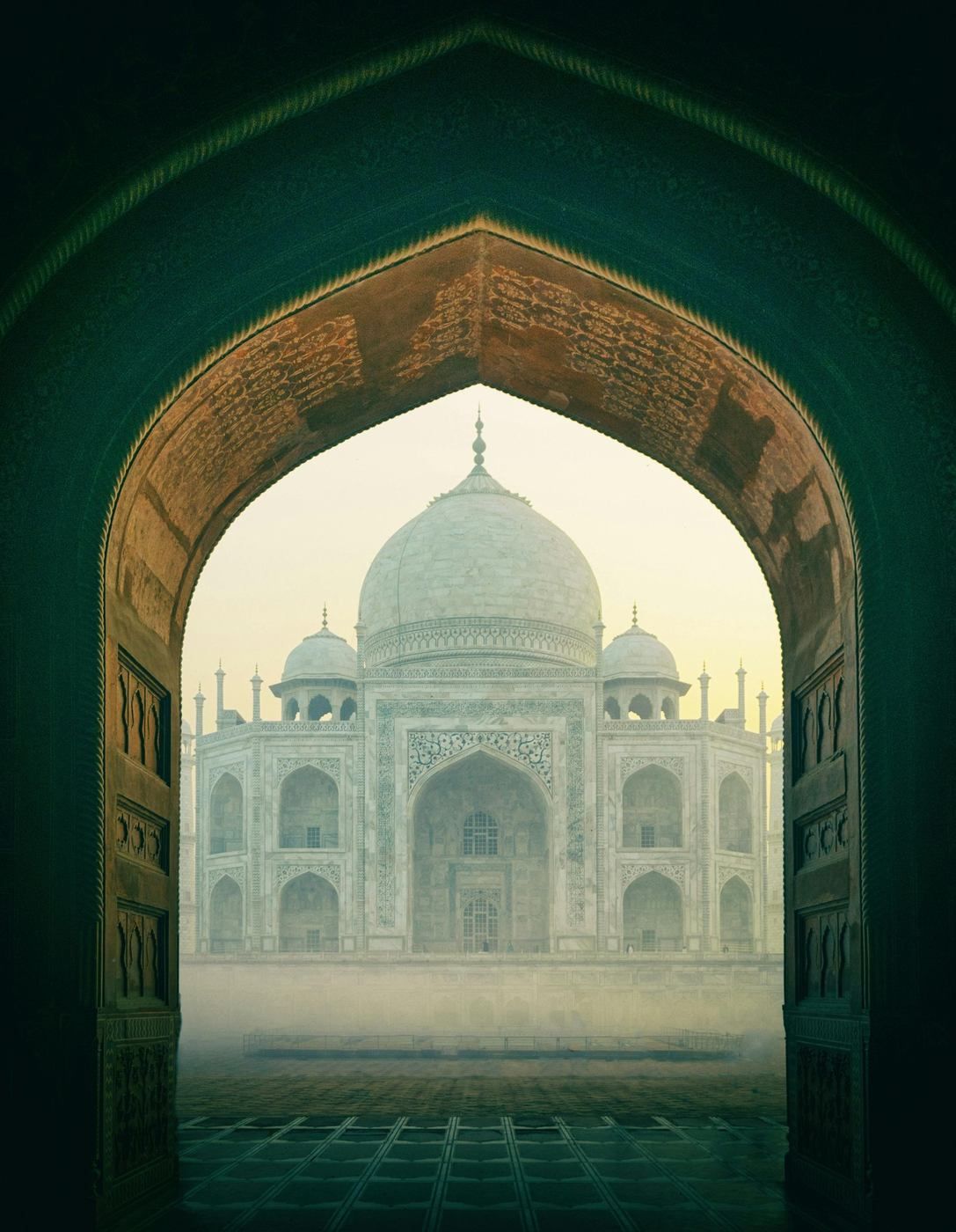 The Taj Mahal framed through a carved archway in Agra, a reminder of home for families moving from the UK to India