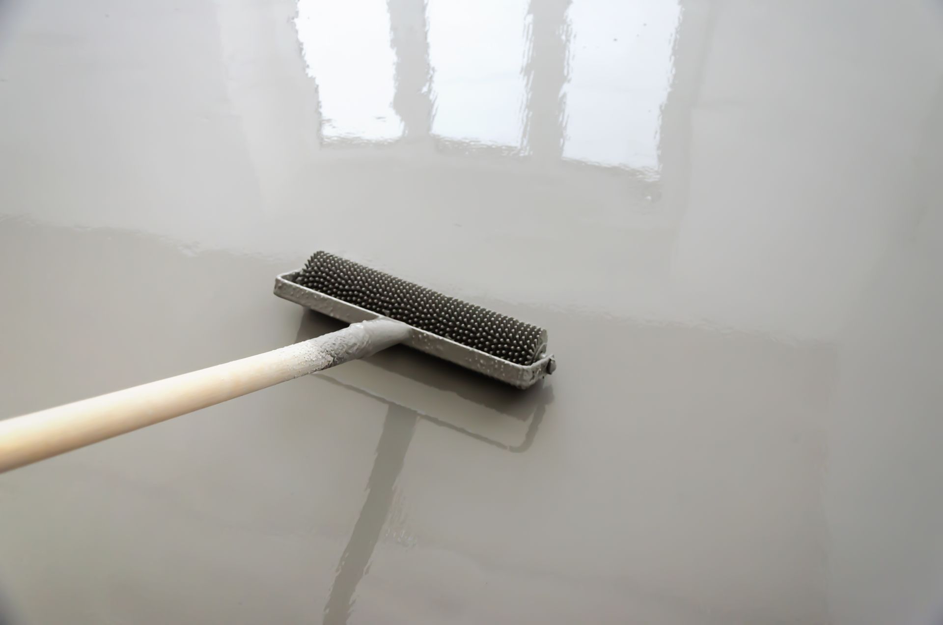 Long-handled mop cleaning a glossy white floor