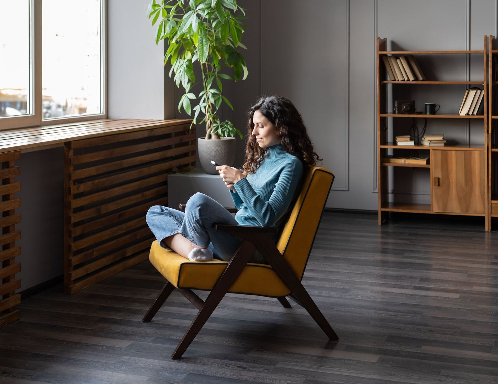 A woman is sitting in a chair using a laptop computer.