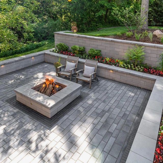 Brick wall with a concrete walkway curving through landscaping.