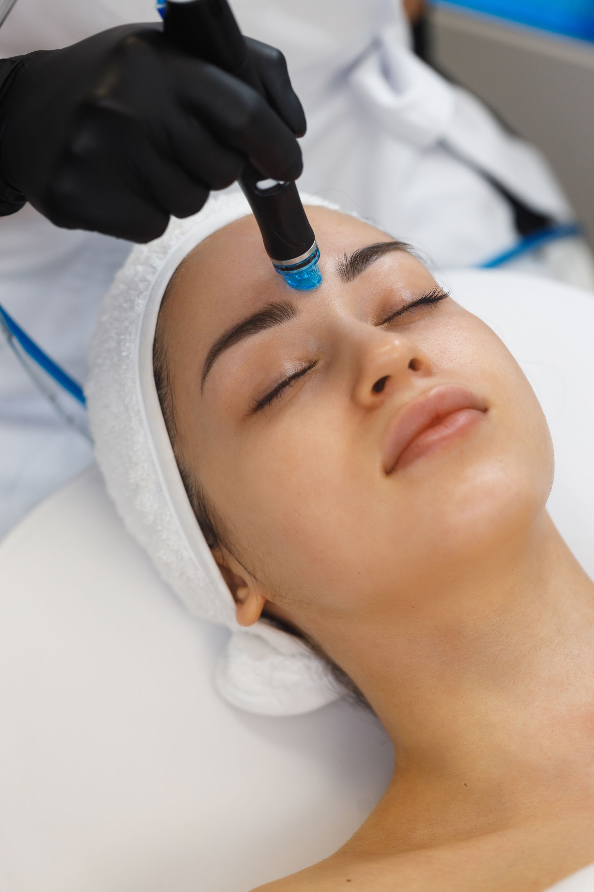 A woman is getting a facial treatment at a beauty salon.