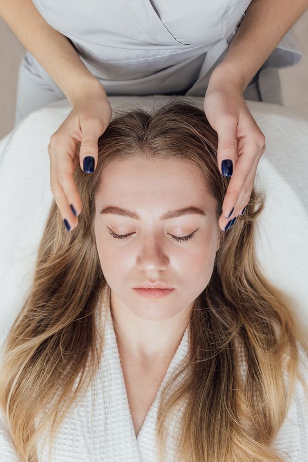 A woman is getting a head massage in a spa.