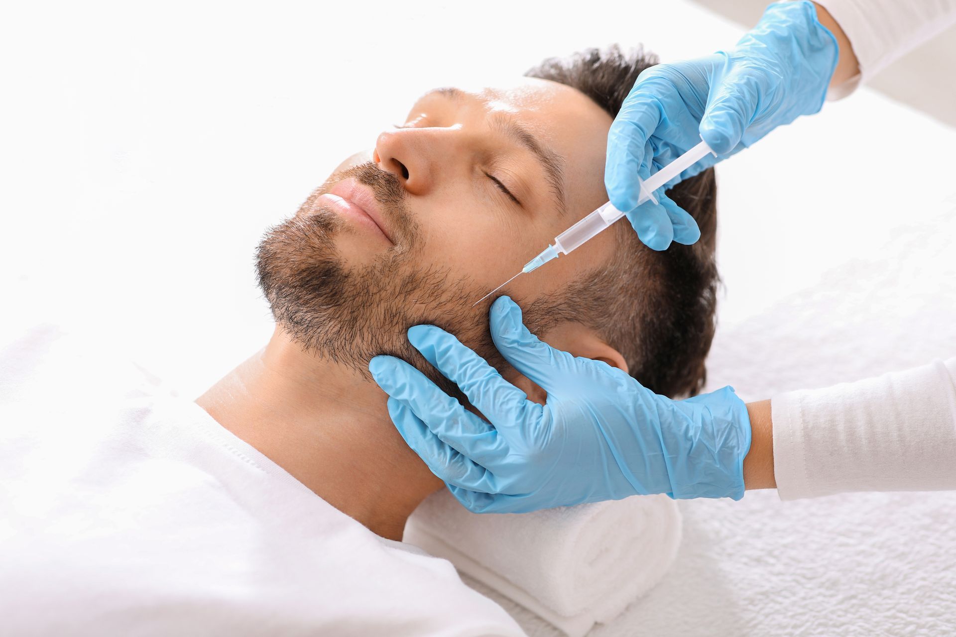 A man is getting a botox injection in his face.