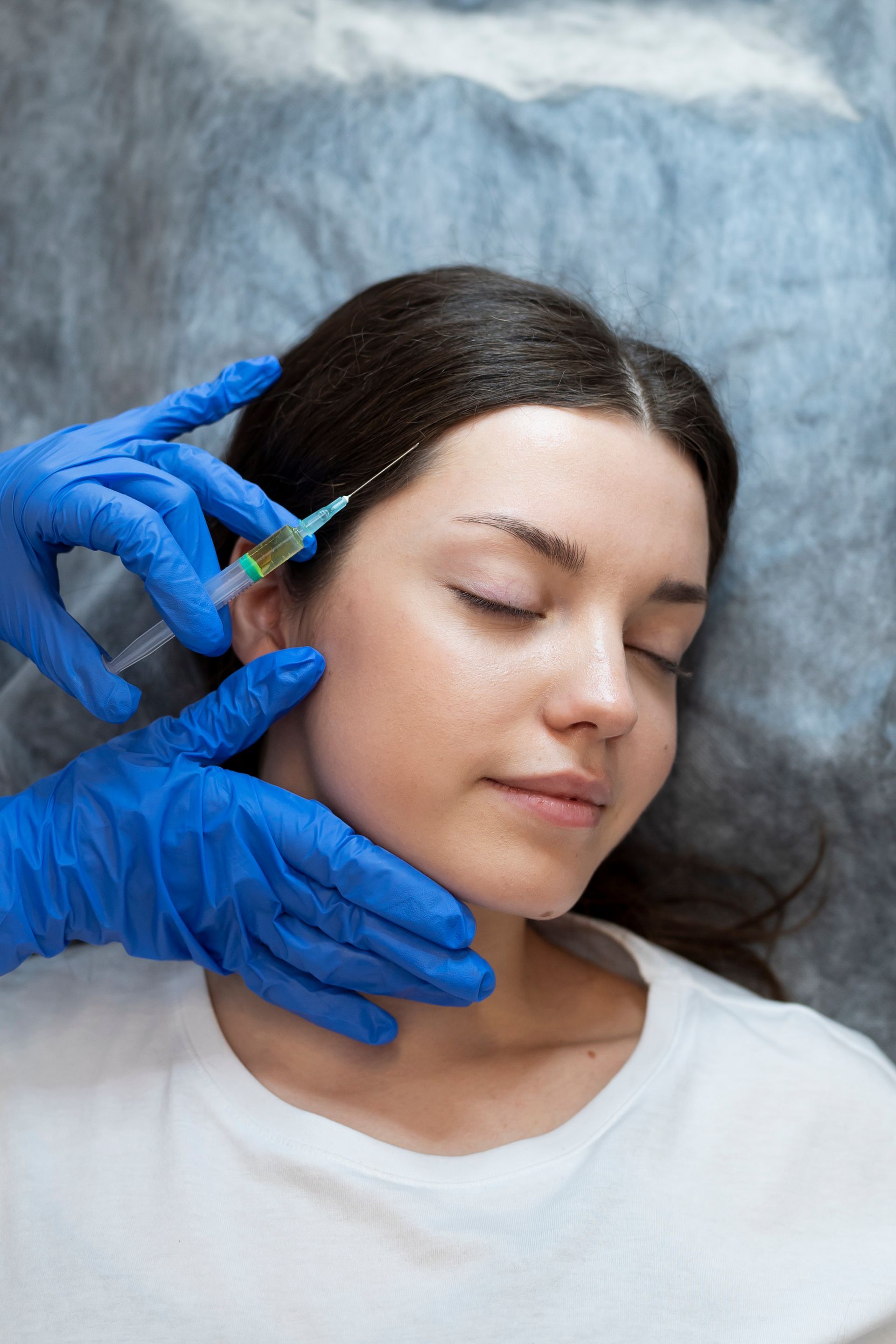 A woman is getting a botox injection in her face.