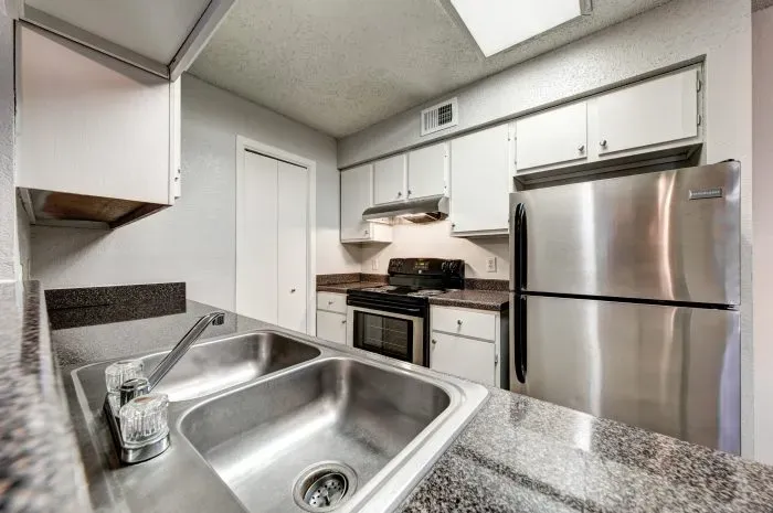Kitchen with stainless steel stove and refrigerator.