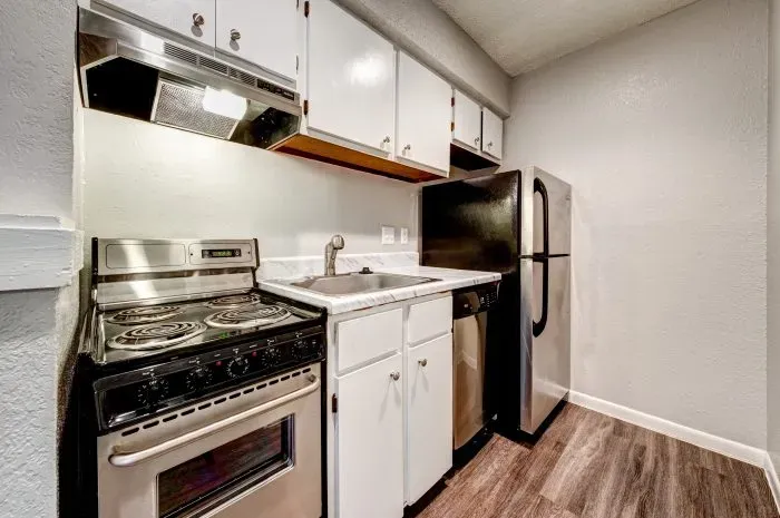 Kitchen with stainless steel stove and refrigerator.