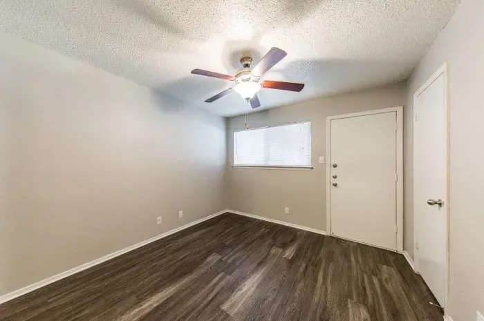 Pecan Square - living room with grey laminate flooring and ceiling fan.