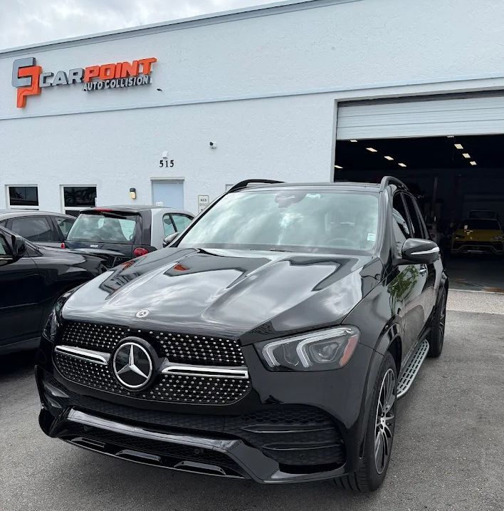 Black Mercedes SUV parked outside a car dealership building