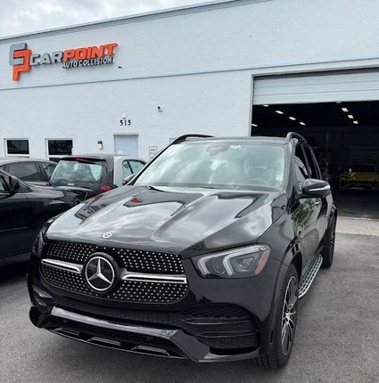 Black Mercedes SUV parked outside a car dealership building