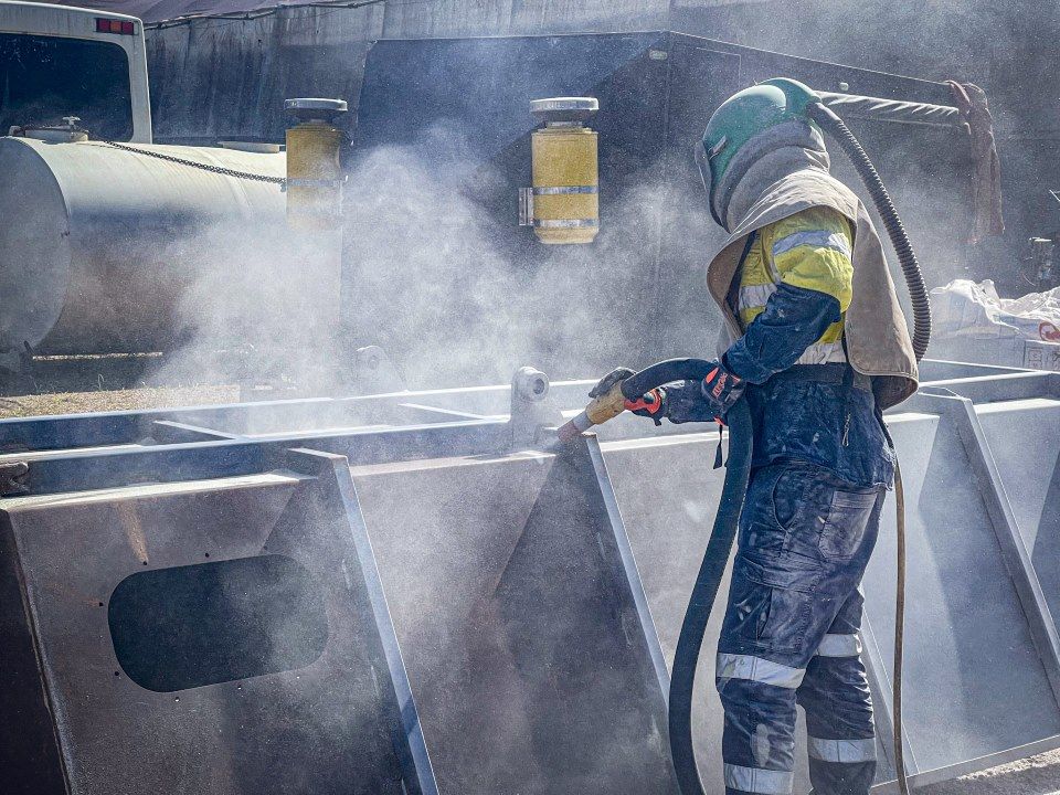 A Man Wearing a Helmet is Sandblasting a Metal Structure — Goat Collective in Ballina, NSW
