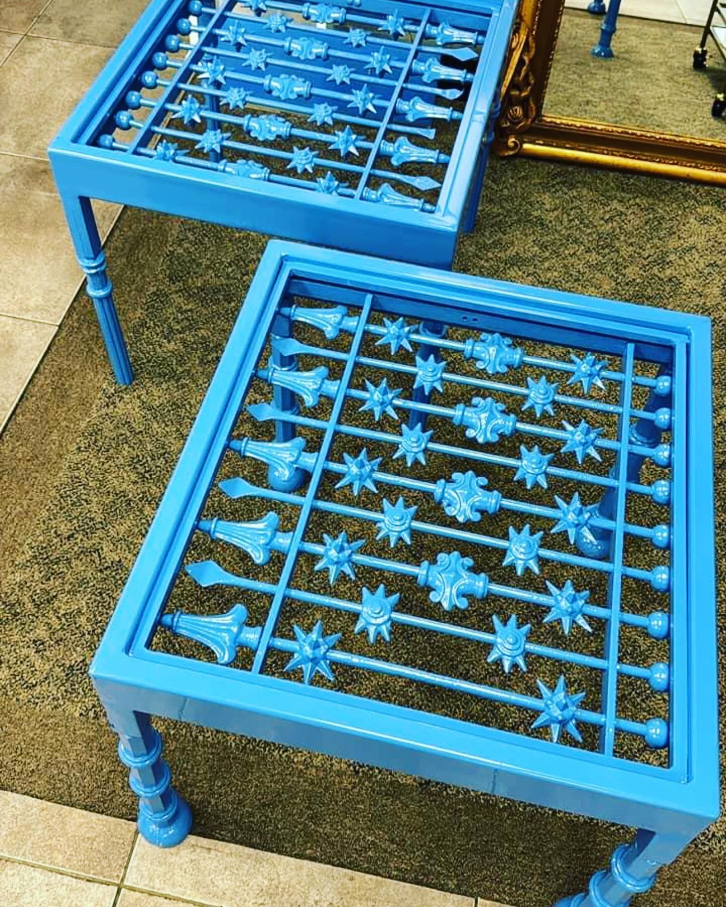 Two blue metal side tables with star-pattern grates on a carpeted floor