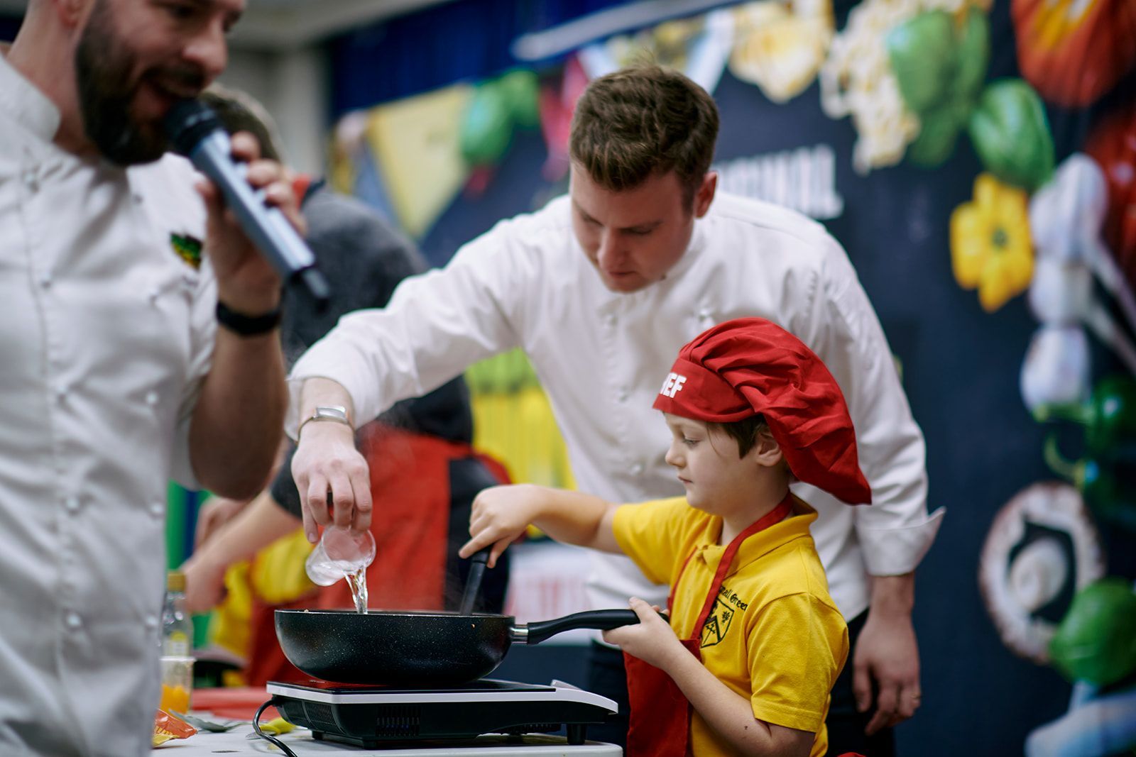 Pupil cooking with a professional chef during the Junior SuperChef healthy eating workshop for schools 