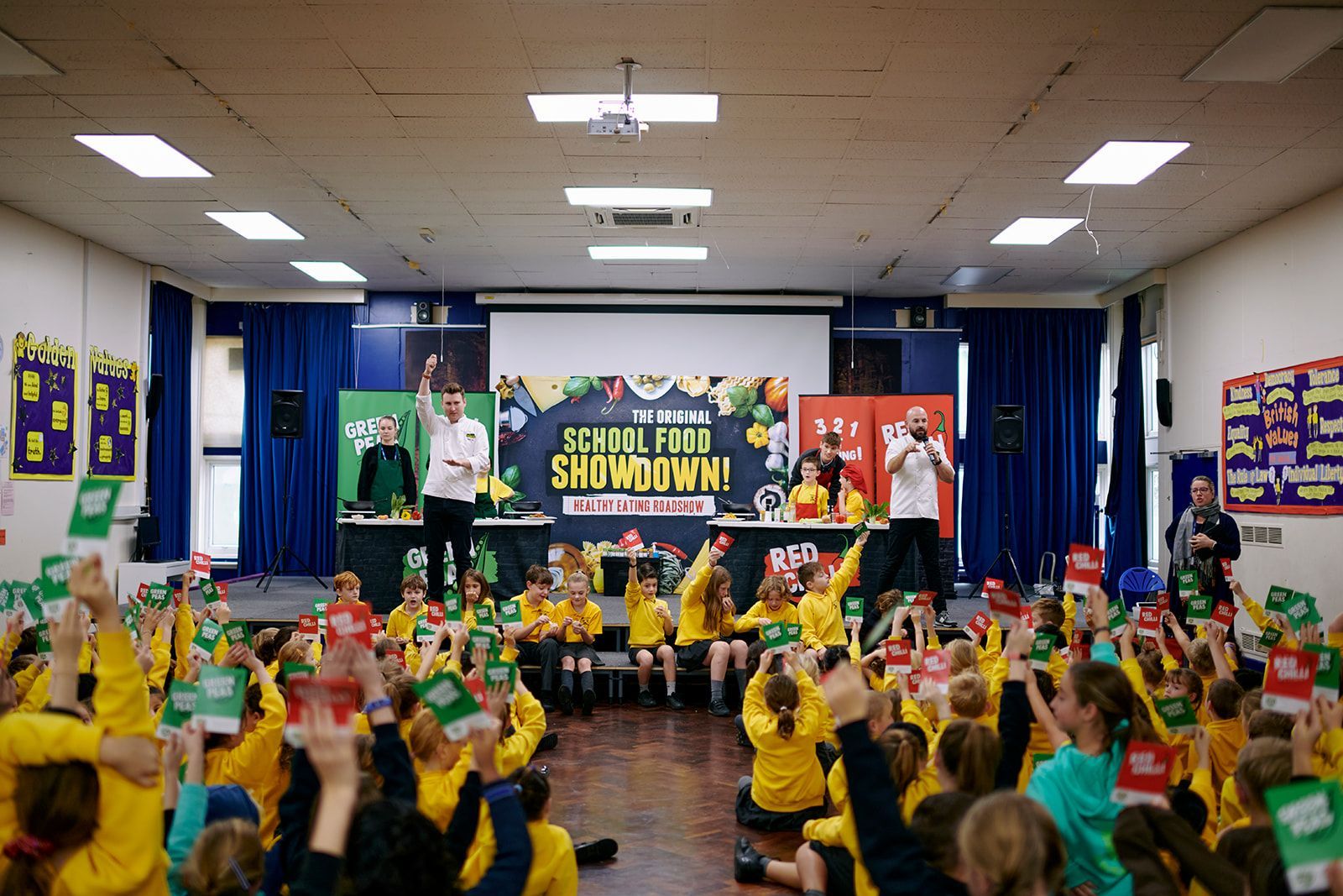 Children in yellow shirts with hands raised during a
