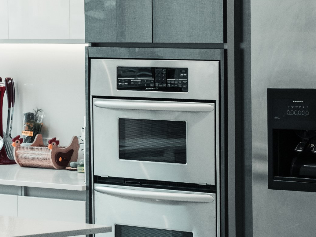 Stainless steel double oven built into a kitchen cabinet.