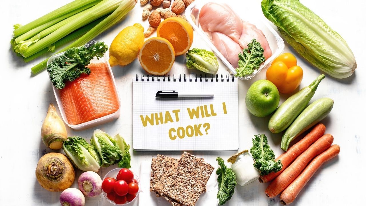 Assortment of fresh produce and meat surrounds a notepad with