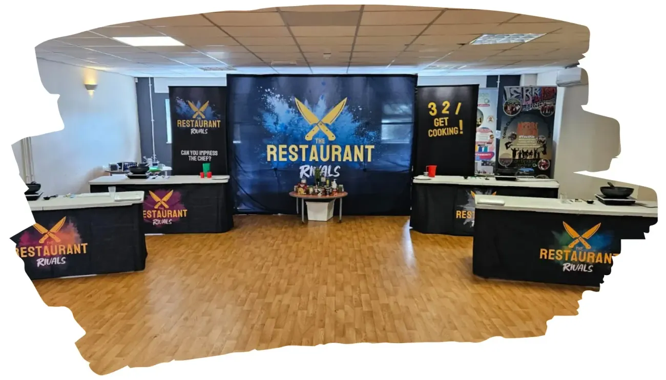 Restaurant-themed event space with branded tables, backdrop, and products on display.