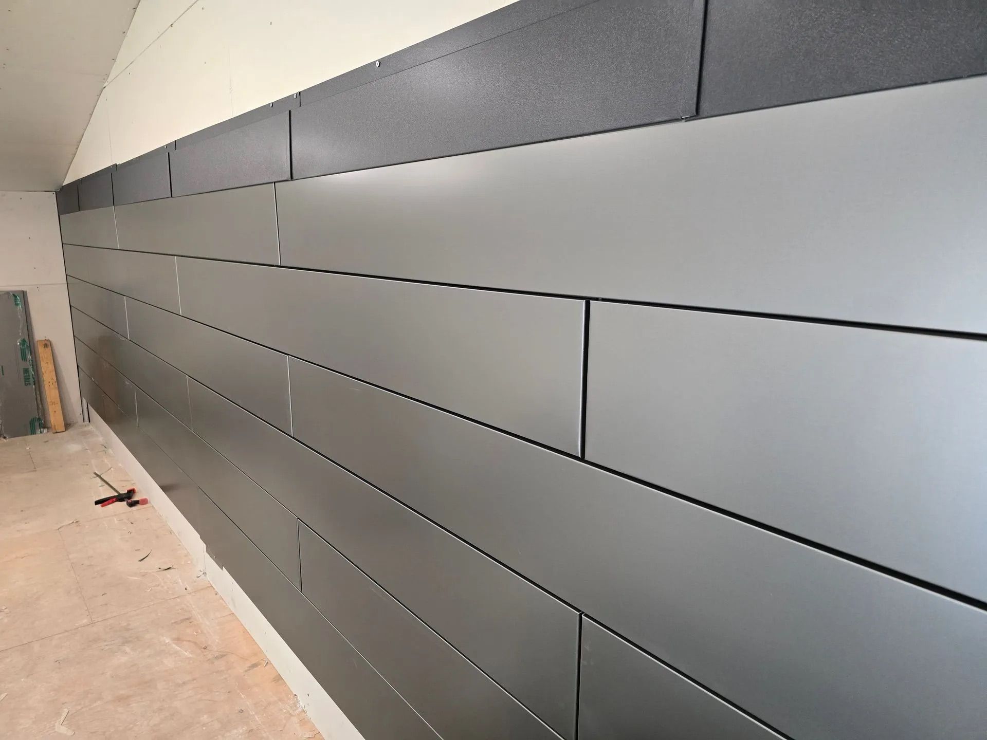 Long gray wall panels in a hallway or corridor under construction
