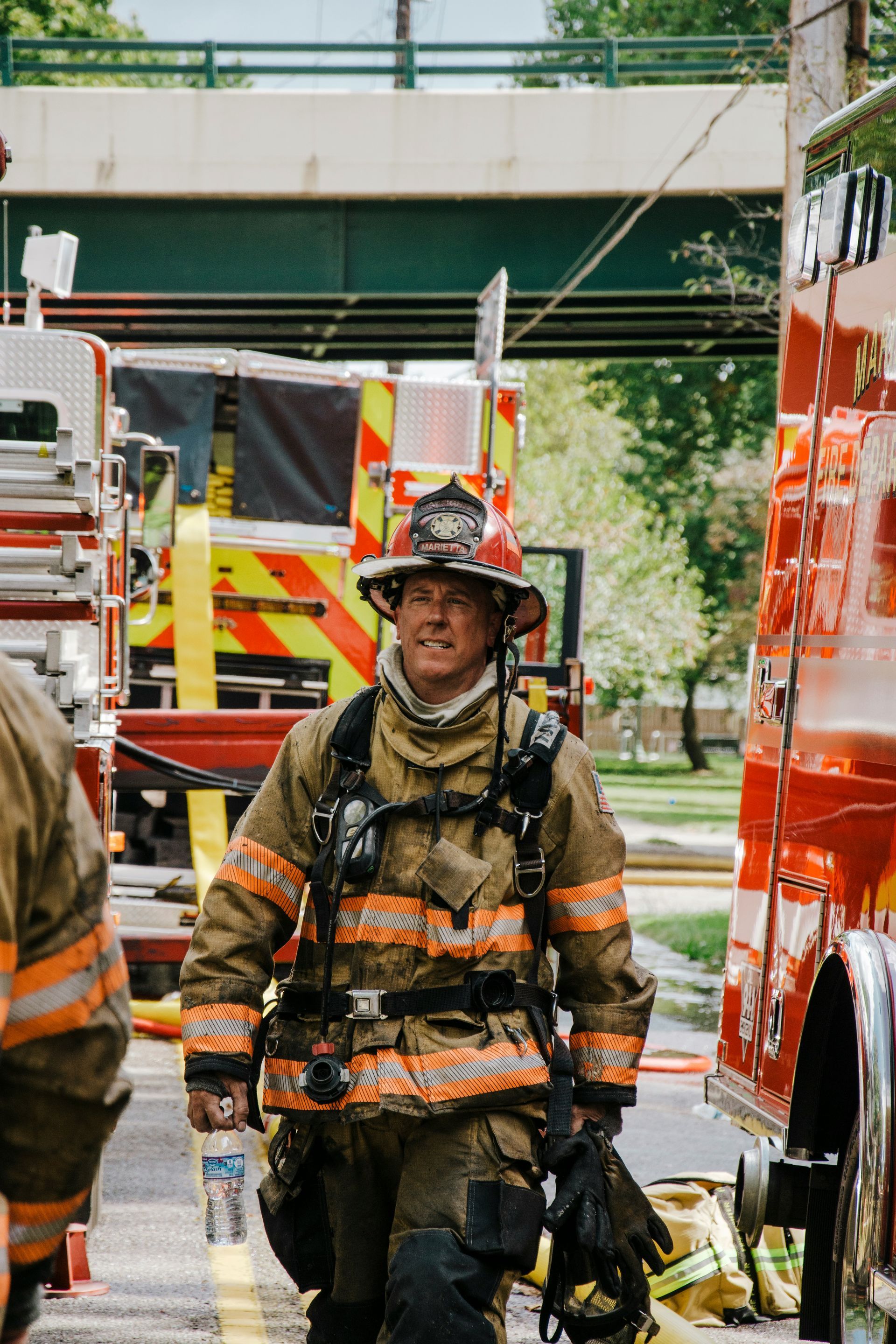 A firefighter is standing in front of a fire truck.