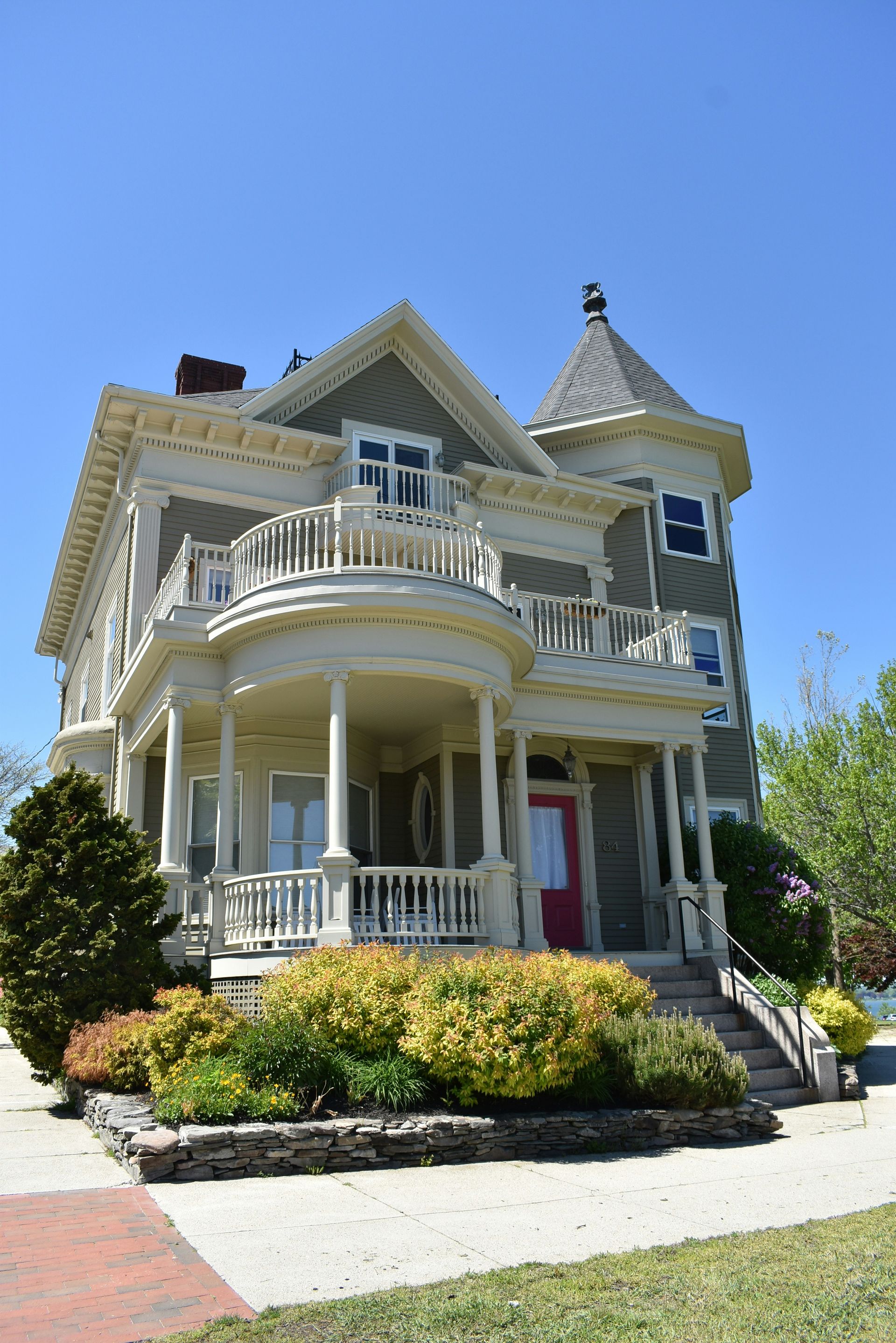 A large house with a large porch and a tower on top of it.