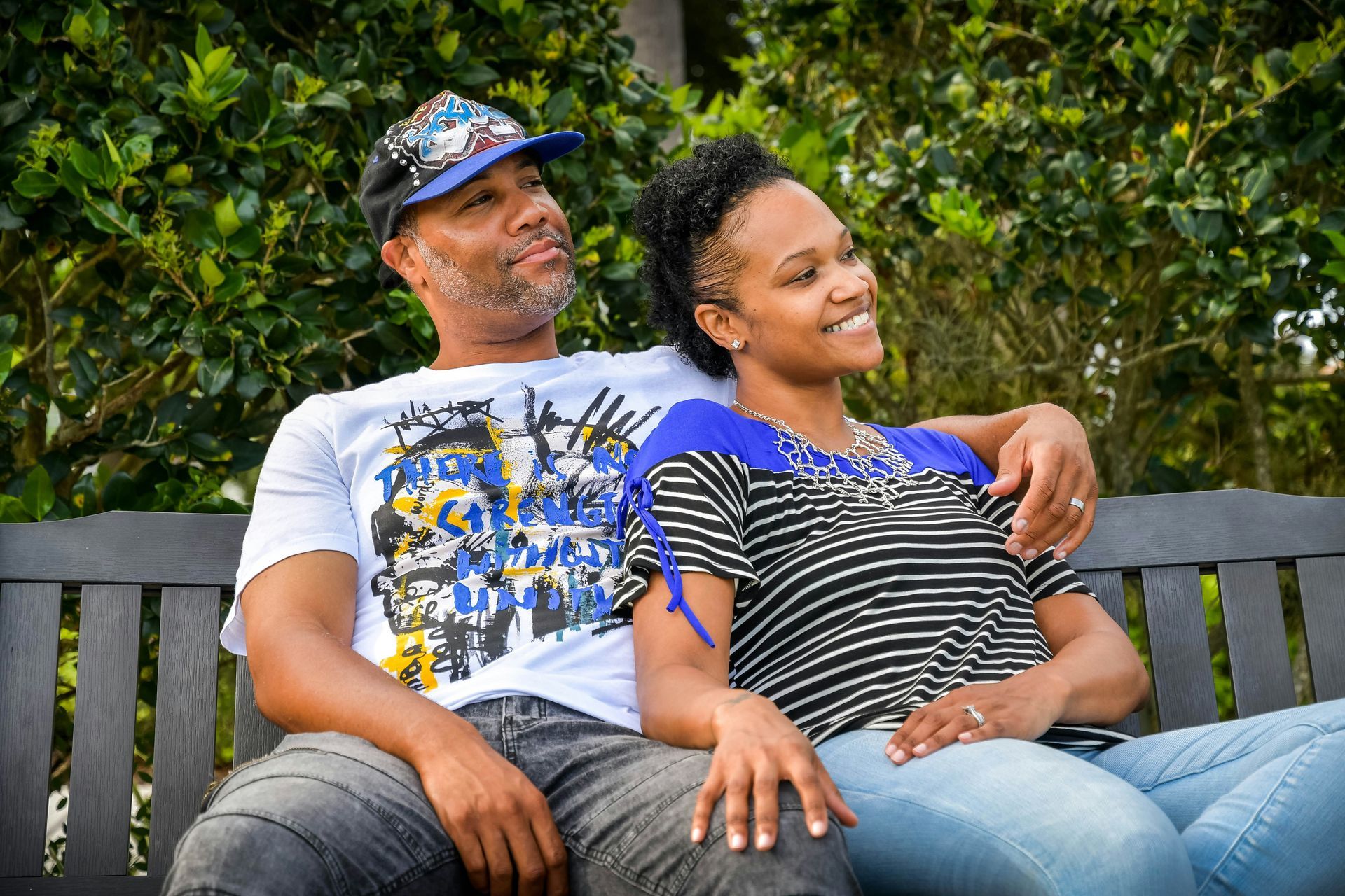 A man and a woman are sitting on a park bench.