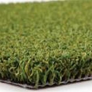 Close-up of a patch of artificial green grass on a white surface