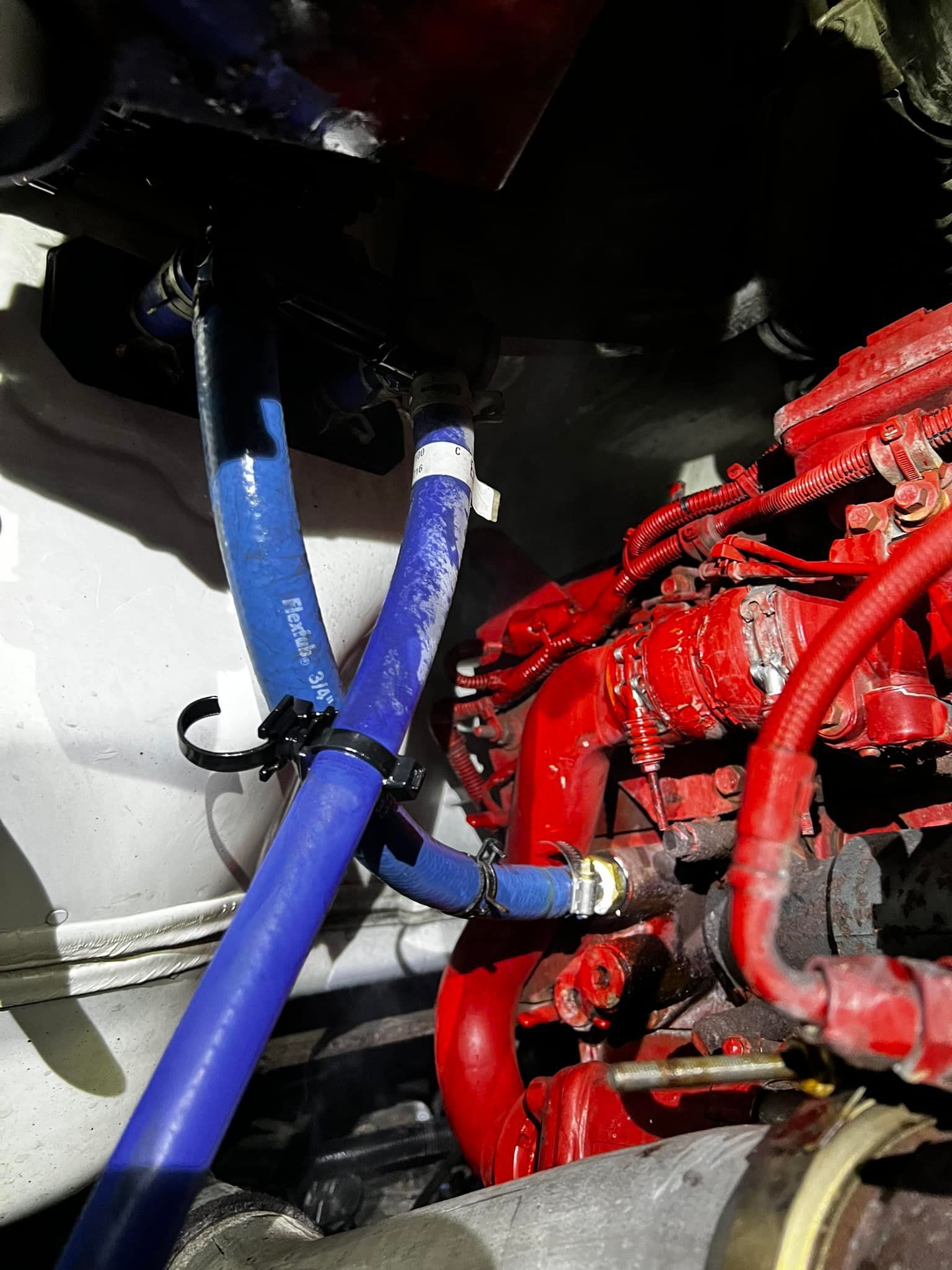 Blue hoses connected to a red engine in an automotive setting.